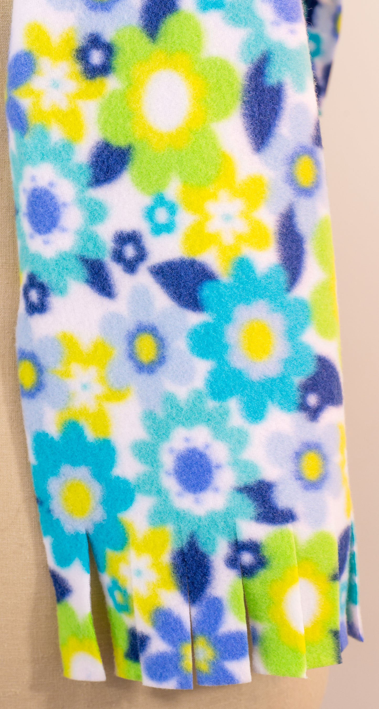 A blue and yellow floral polar fleece scarf with fringe displayed on a mannequin.
Photo by Karen King [additional_image_link]