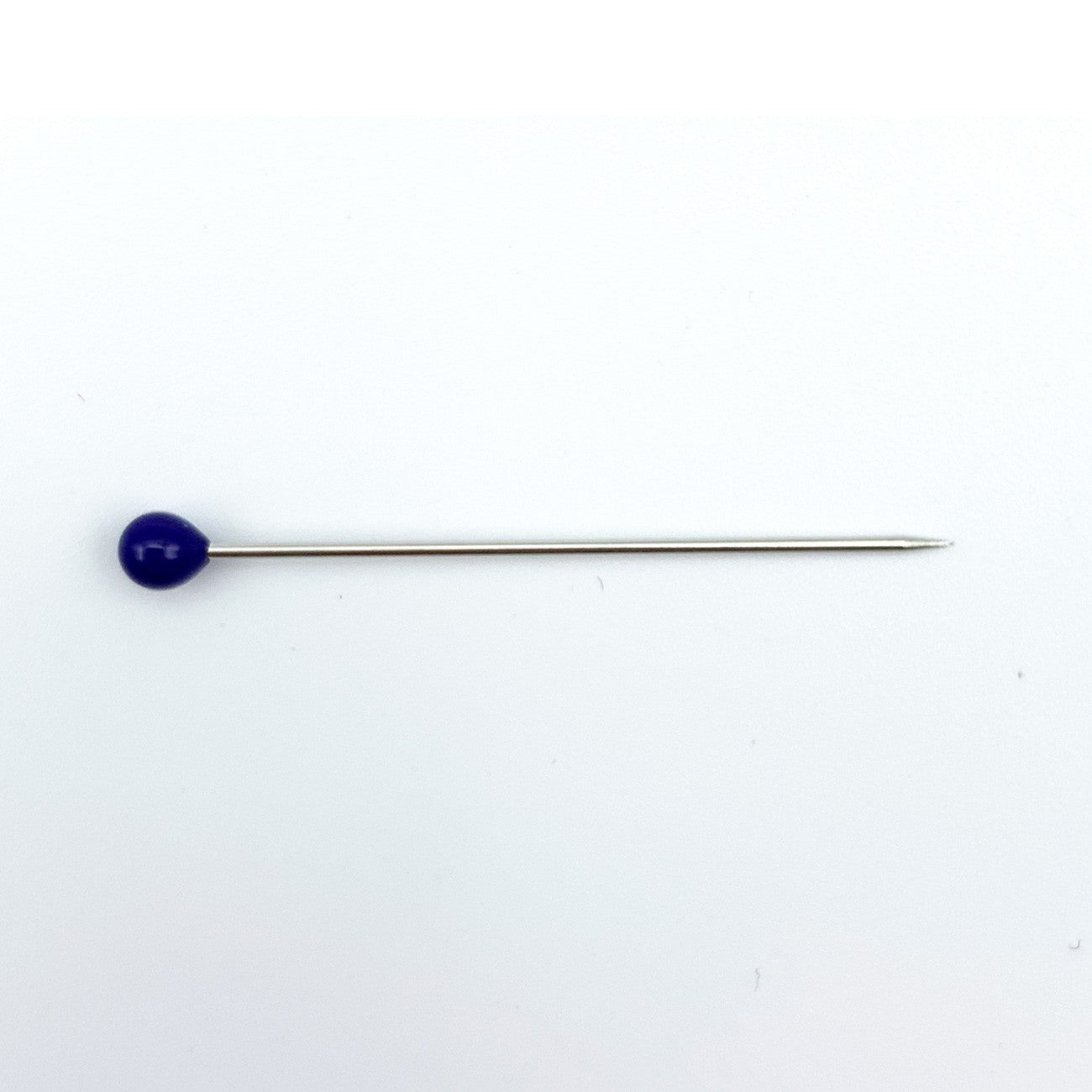 A long silver metal pin with a small, round, dark blue cabochon gemstone on one end, set against a plain white background.
Photo by Bohin [additional_image_link]