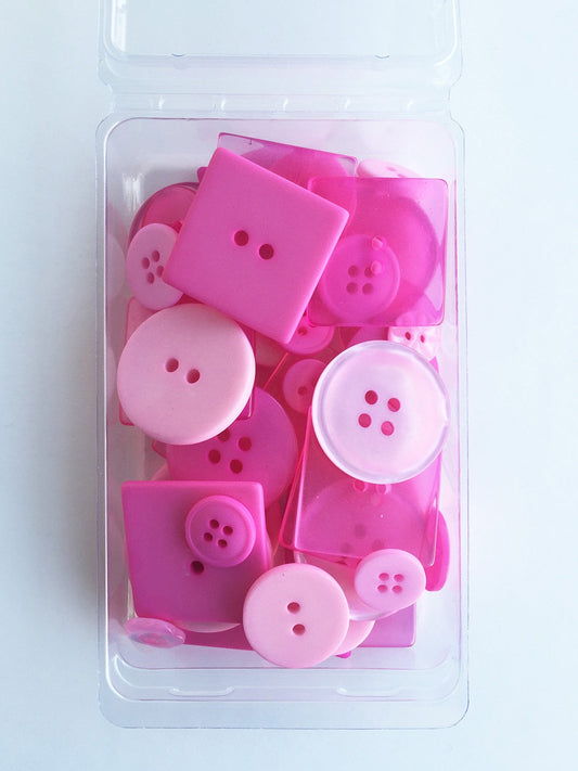 A clear plastic container holding 55 bubblegum pink buttons of various sizes, from 1/4in to 1 1/8in, for crafting and sewing projects.
Photo by JustAnotherButtonCompany.com [image_link]