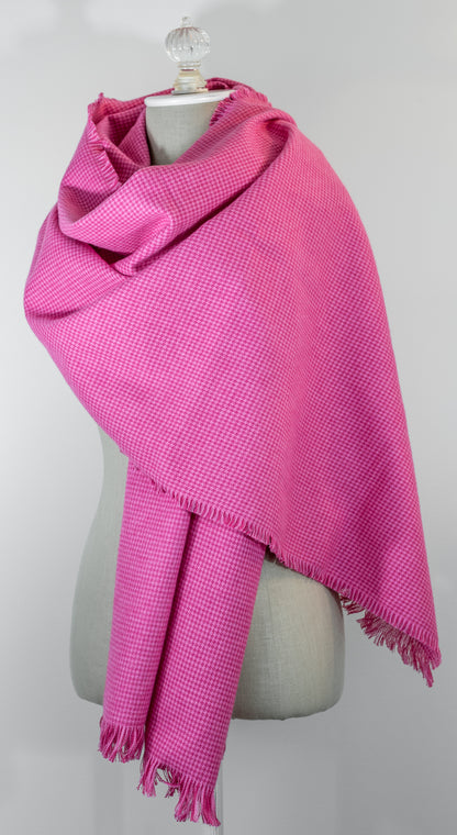 A bubblegum pink houndstooth flannel shawl with a fringe, displayed on a mannequin.
Photo by Karen King [additional_image_link]