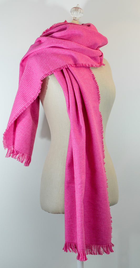 A bubblegum pink houndstooth flannel shawl with a fringe, displayed on a mannequin.
Photo by Karen King [image_link]