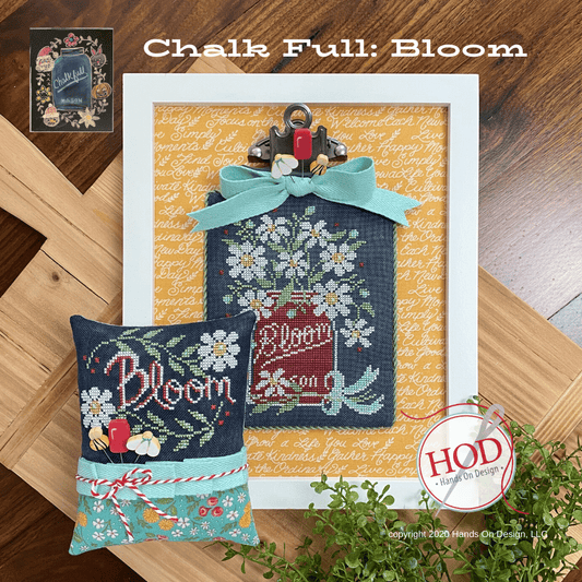 Decorative pillows with 'Bloom' text and a framed artwork on a wooden surface, featuring the brand 'HOD'.
Photo by HandsOnDesign.biz [image_link]