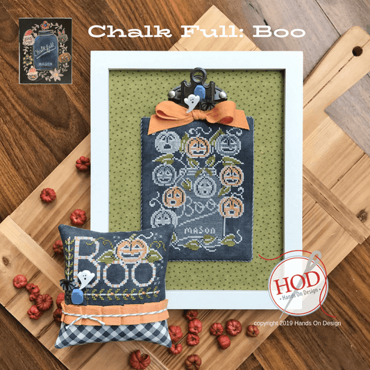 Halloween-themed cross-stitched pillow and decorative item on a wooden surface with 'Hands On Design' branding.
Photo by HandsOnDesign.biz [image_link]