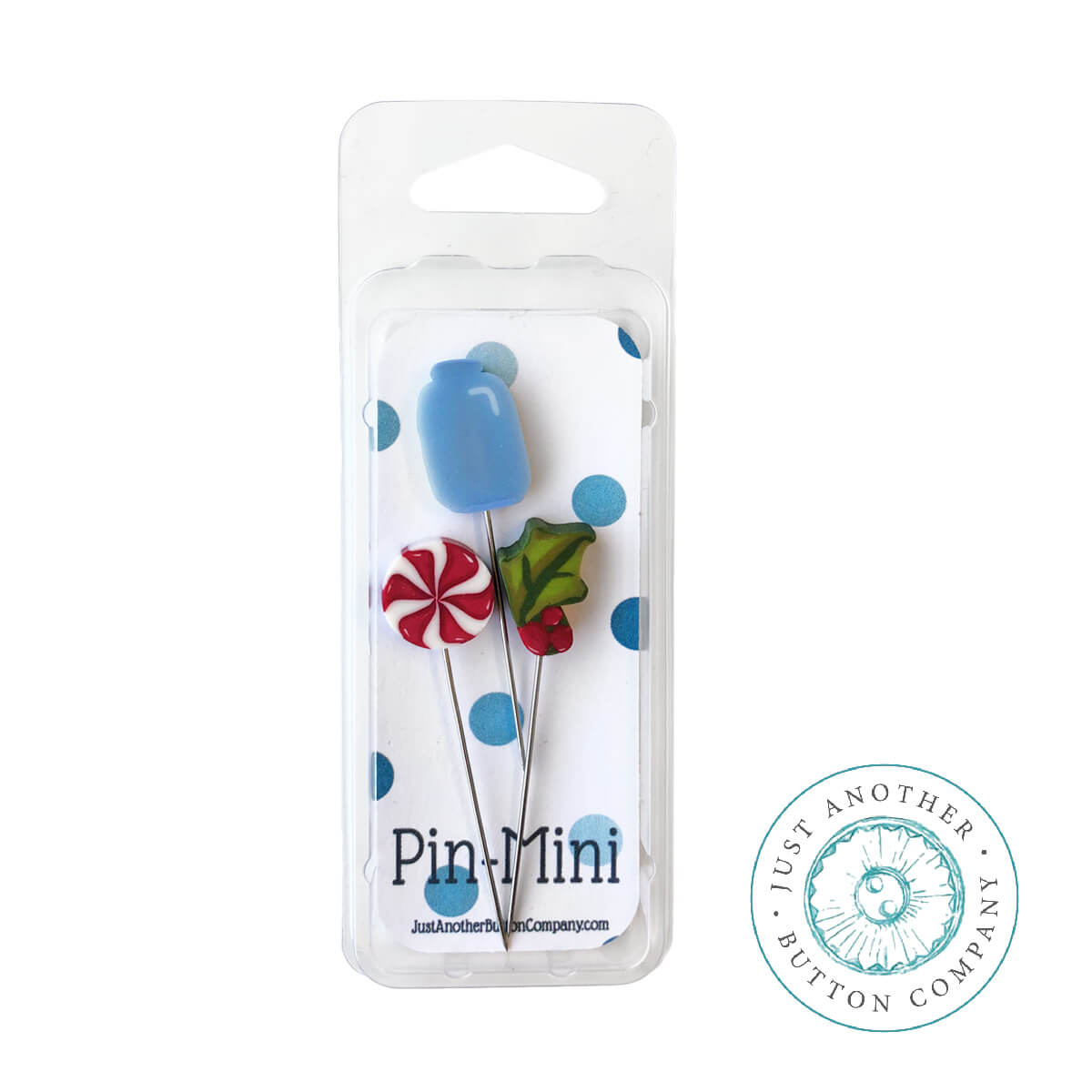 Three mini decorative pins in a clear blister pack with a white backing card. The pins include a blue tulip, a red-and-white peppermint candy, and a green leaf with red berries.
Photo by Justanotherbuttoncompany.com [additional_image_link]