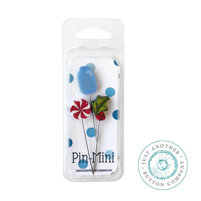 Three mini decorative pins in a clear blister pack with a white backing card. The pins include a blue tulip, a red-and-white peppermint candy, and a green leaf with red berries.
Photo by Justanotherbuttoncompany.com [additional_image_link]