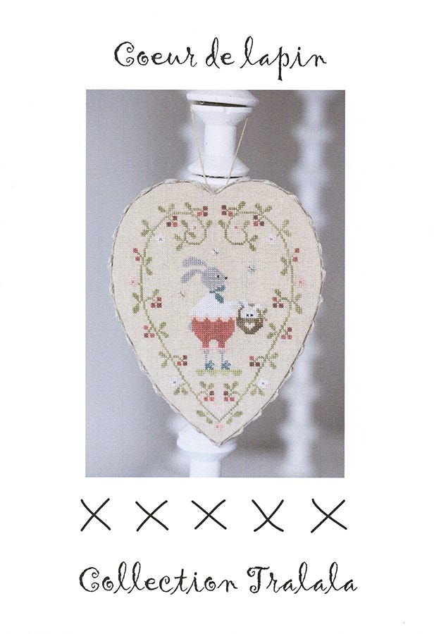 Cross stitch embroidery kit depicting a stylized rabbit with a heart-shaped body, surrounded by a floral pattern, intended for use in a craft or sewing project.
Photo by Tralala [image_link]