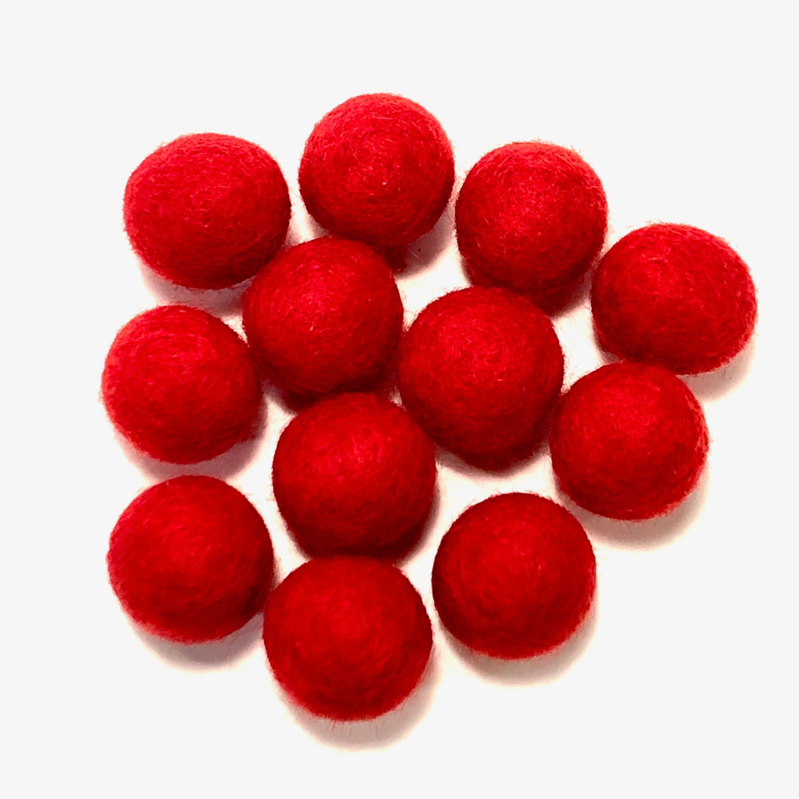 A cluster of ten small, bright red felt balls arranged on a plain white background.
[additional_image_link]