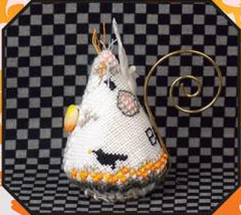 A handmade cross-stitch ghost mouse with a white body, black embroidered details, orange and yellow accents, and a gold spiral wire tail, set against a black and gray checkered background.
Photo by JustNan.com [image_link]