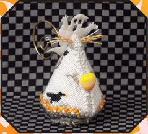 A handmade Halloween ornament shaped like a  candy corn ghost, featuring a white cross-stitch pattern with a ghost, a black bird, and orange details, complete with a gold metal ring tail for hanging.
Photo by JustNan.com [additional_image_link]