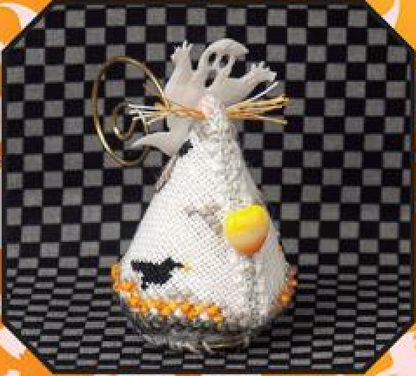 A handmade Halloween ornament shaped like a  candy corn ghost, featuring a white cross-stitch pattern with a ghost, a black bird, and orange details, complete with a gold metal ring tail for hanging.
Photo by JustNan.com [additional_image_link]