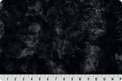 Black textured fabric with a fuzzy, plush surface shown close up, with a white ruler at the bottom edge for scale.
Photo by Shannon Fabrics [additional_image_link]
