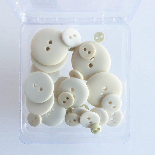 A clear plastic container holding 25 off-white buttons in varying sizes, designed for sewing and crafting projects.
Photo by JustAnotherButtonCompany.com [image_link]
