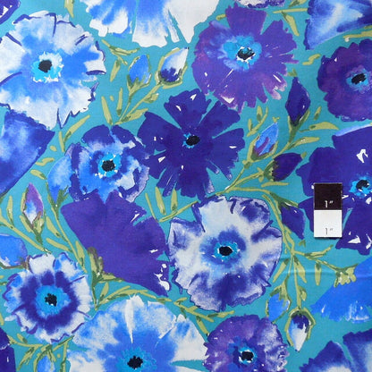 A close-up of a watercolor floral pattern featuring blue, purple, and white flowers with yellow-green stems on a teal background.
[additional_image_link]