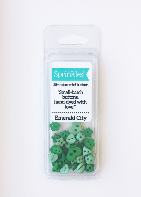 Pack of 35+ micro-mint green buttons from Sprinkles! brand, labeled 'Emerald City', in a clear plastic blister pack against a white background.
Photo by JustAnotherButtonCompany.com [image_link]