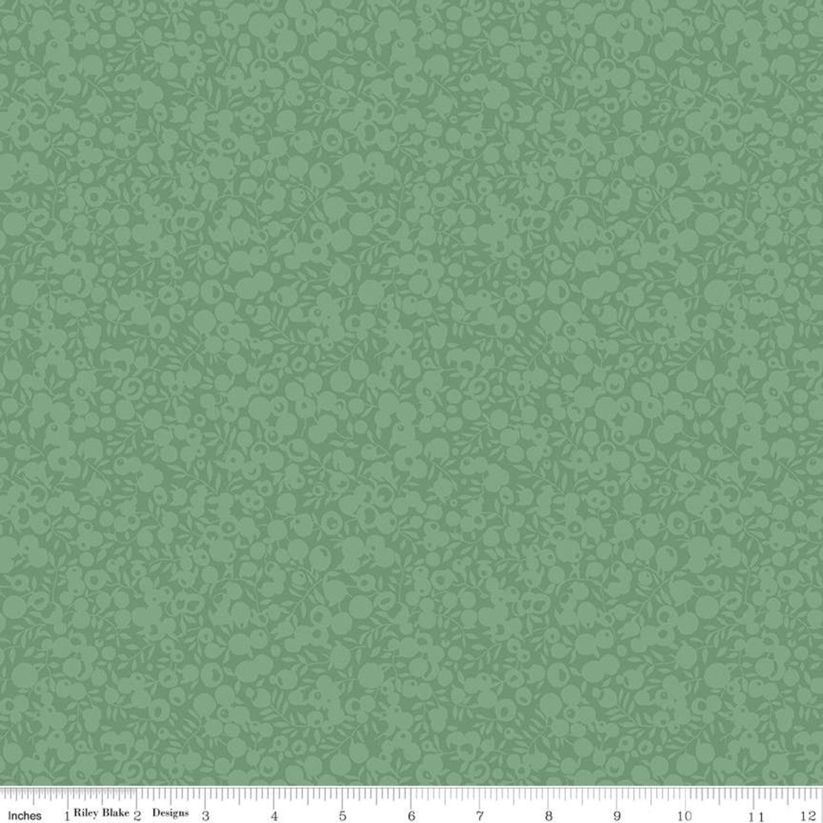 A close-up of a green fabric or wallpaper pattern swatch with a repeating floral and scroll motif, plus a ruler strip along the bottom edge showing measurements.
Photo by RileyBlakeDesigns.com [additional_image_link]