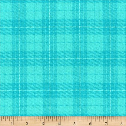 A close-up of a turquoise and teal plaid fabric pattern with a wooden ruler along the bottom edge showing measurement markings.
[additional_image_link]