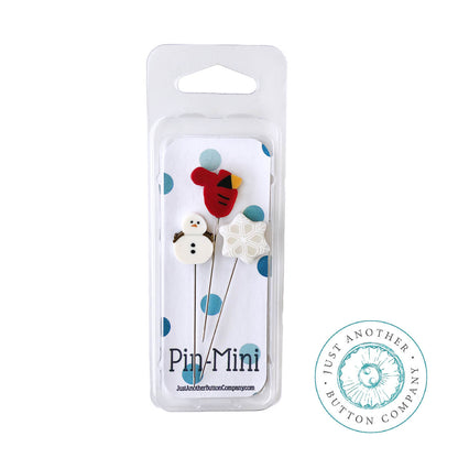 Three mini holiday-themed buttons in a clear blister pack with a white backing card. The set includes a red bird, a white snowman, and a white snowflake on thin metal pins.
[additional_image_link]
