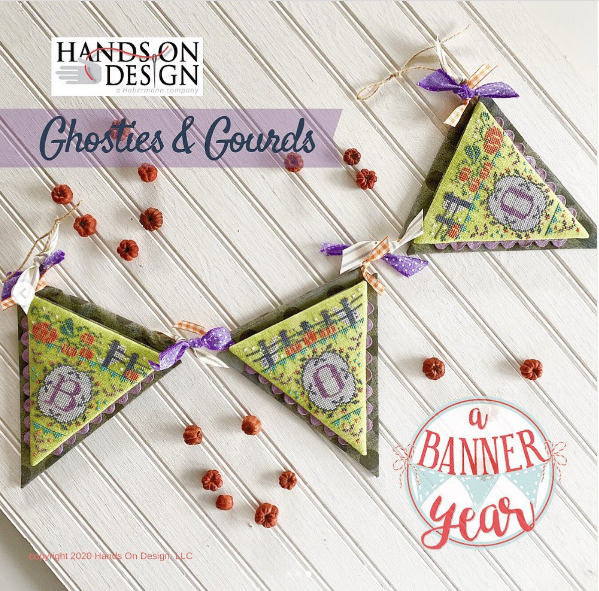 Three triangular fabric bunting flags with floral embroidery and purple ribbon bows, arranged on a white wood plank surface with scattered dried red berries. Text overlays read 'HANDS ON DESIGN', 'Ghosties & Gourds', and 'a BANNER year'.
[image_link]