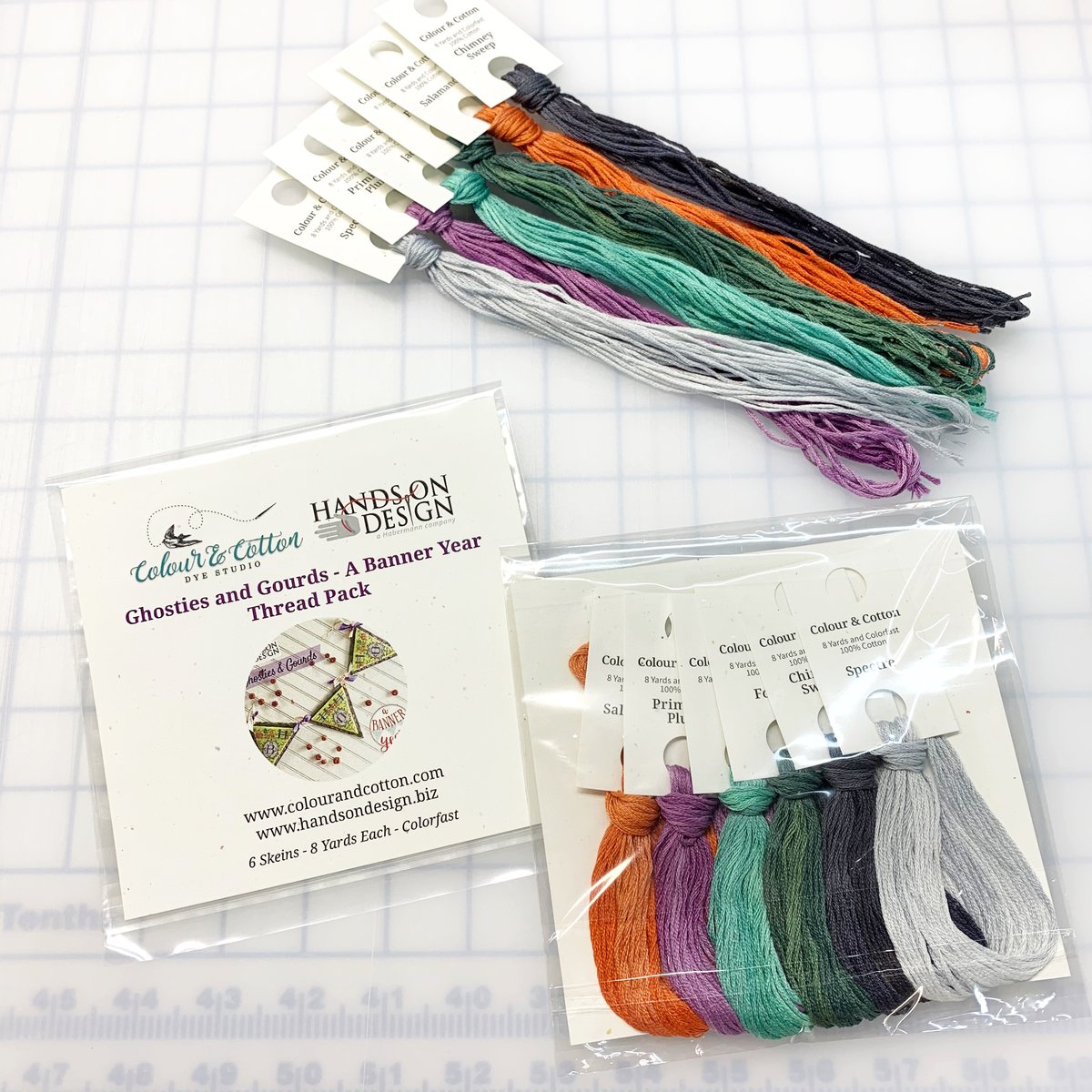 A thread pack set displayed on a white grid background, including loose thread bundles and packaged thread skeins. The visible text on the packaging and tags shows the brand Hands On Design and the line Colour & Cotton.
[additional_image_link]