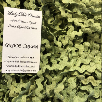 A close-up of olive green ric rac trim filling the frame, with a white paper label card reading 'Lady Dot Creates' and 'GRACE GREEN' placed on top.
[additional_image_link]