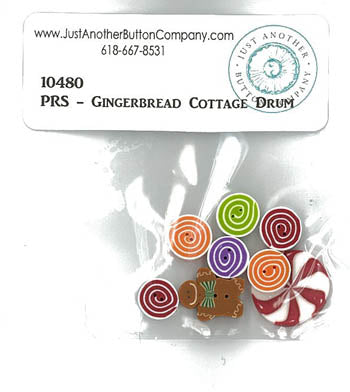 A small clear plastic bag containing several colorful decorative buttons, with a white paper label above showing the text '10480 PRS - Gingerbread Cottage Drum' and the Just Another Button Company branding.
Photo by JABC.com [additional_image_link]
