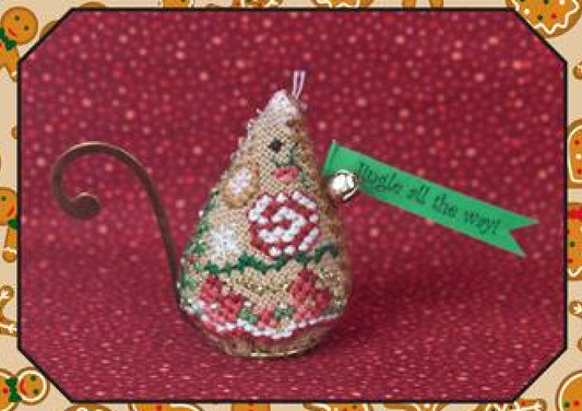 Cross stitch embroidery kit depicting a gingerbread jingle mouse with a green ribbon, gold swirl hanger, and red and green floral details, on a red background.
Photo by JustNan.com [image_link]