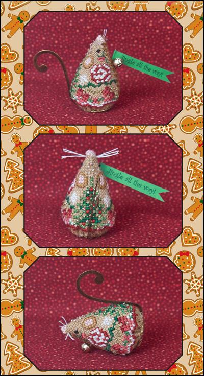 Cross stitch embroidery kit depicting a gingerbread jingle mouse with a green ribbon, gold swirl hanger, and red and green floral details, on a red background.
Photo by JustNan.com [additional_image_link]