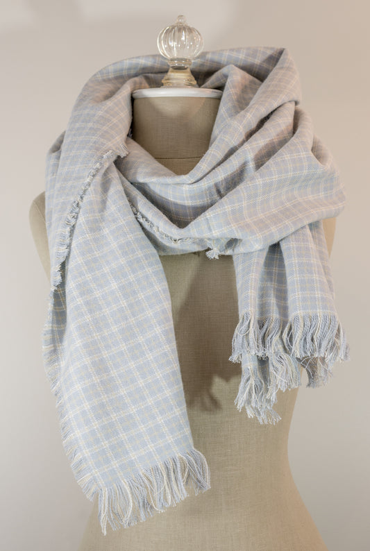 A gray, beige, and white plaid flannel scarf displayed on a mannequin bust, with fringed ends visible.
Photo by Karen King [image_link]
