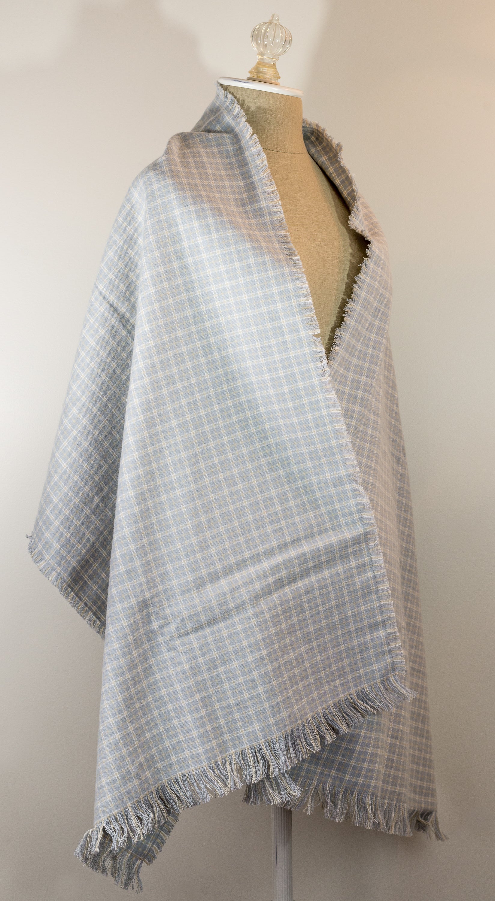 A gray, beige, and white plaid flannel scarf displayed on a mannequin bust, with fringed ends visible.
Photo by Karen King [additional_image_link]