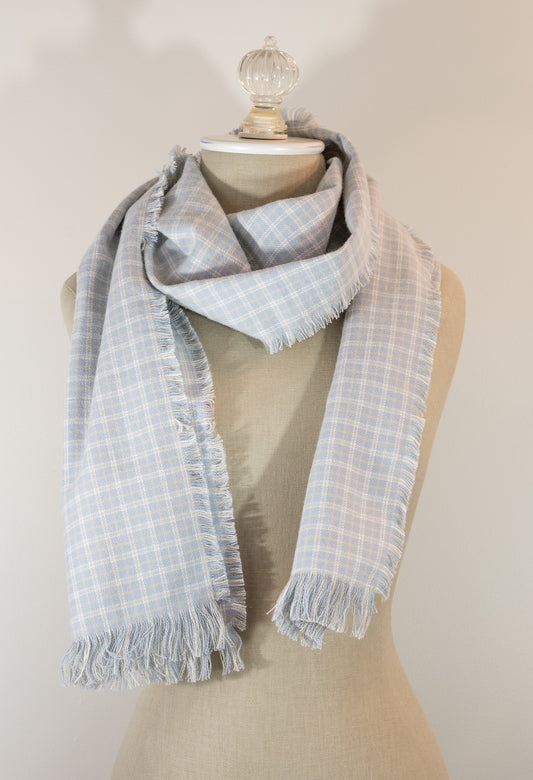A gray, beige, and white plaid flannel scarf displayed on a mannequin, with the texture of the fabric visible at the fringe.
Photo by Karen King  [image_link]