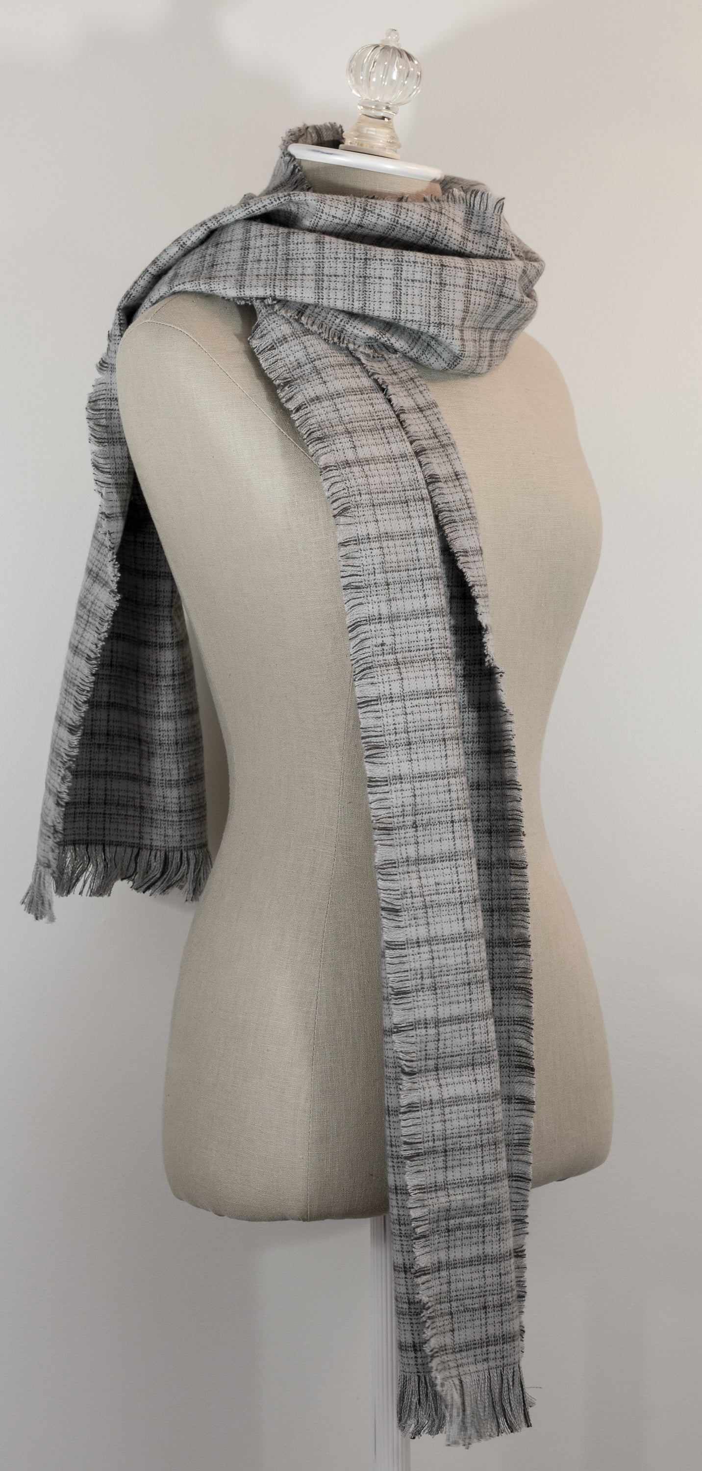 A gray tartan plaid flannel scarf with fringe, displayed on a mannequin.
Photo by Karen King  [additional_image_link]