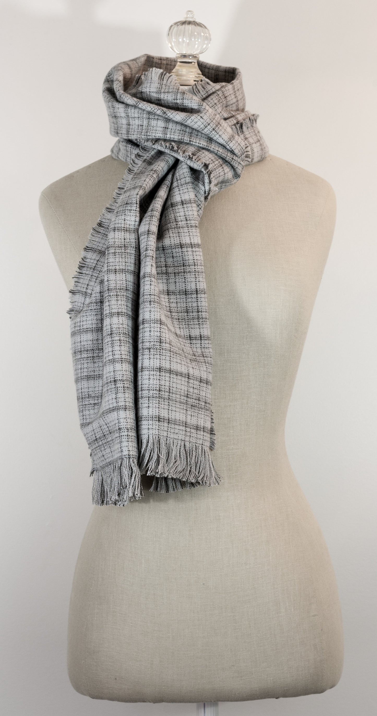 A gray tartan plaid flannel scarf with fringe, displayed on a mannequin.
Photo by Karen King  [additional_image_link]