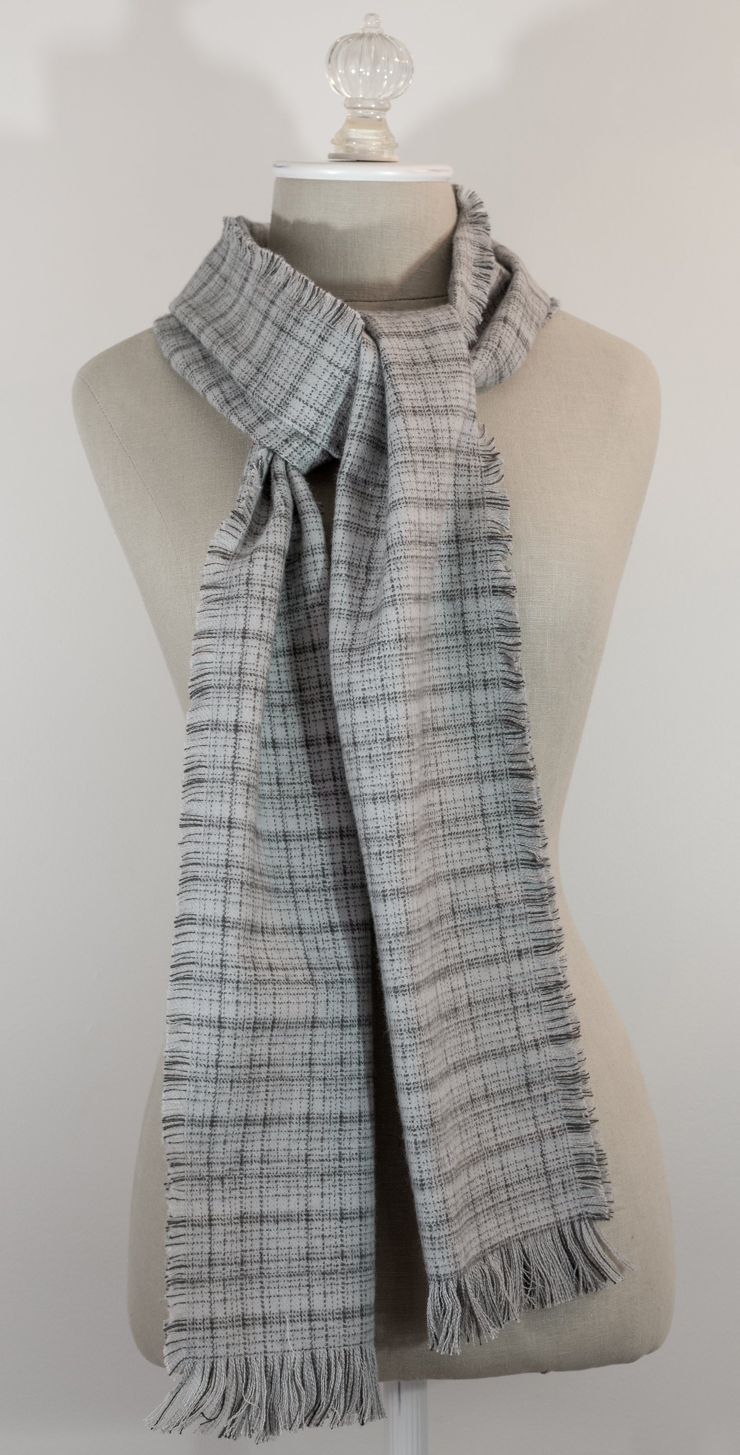 A gray tartan plaid flannel scarf with fringe, displayed on a mannequin.
Photo by Karen King  [additional_image_link]