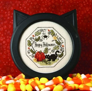 A completed cross stitch embroidery kit depicting a Halloween-themed design with a black kitty, pumpkin, and decorative beads.
Photo by The Sweetheart Tree [image_link]
