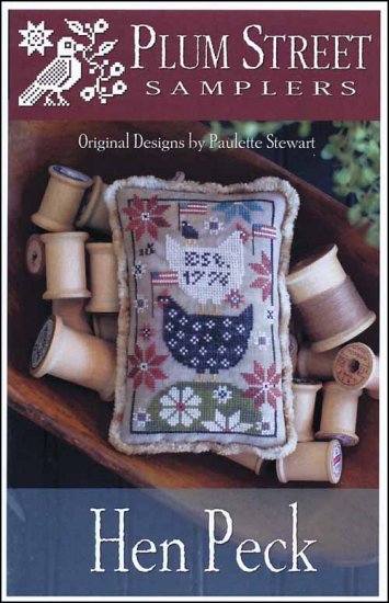 A cross stitch embroidery kit depicting three chicken-shaped characters on a quilt with floral and patriotic-themed elements, accompanied by various colored threads and a piece of chenille trim.
Photo by PlumStreetSamplers.com [image_link]