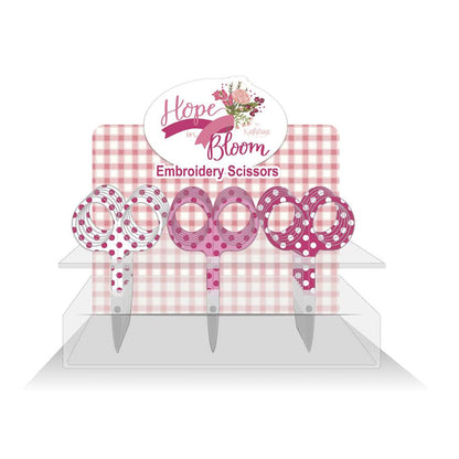 A set of embroidery scissors with white, pink, and hot pink polka dots, displayed on a pink and white checkered background with 'Hope in Bloom' branding.
Photo by RileyBlakeDesigns.com [image_link]