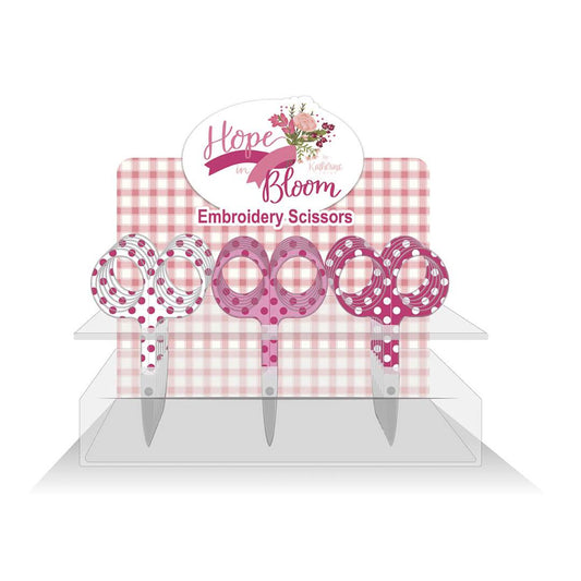 A set of embroidery scissors with white, pink, and hot pink polka dots, displayed on a pink and white checkered background with 'Hope in Bloom' branding.
Photo by RileyBlakeDesigns.com [image_link]