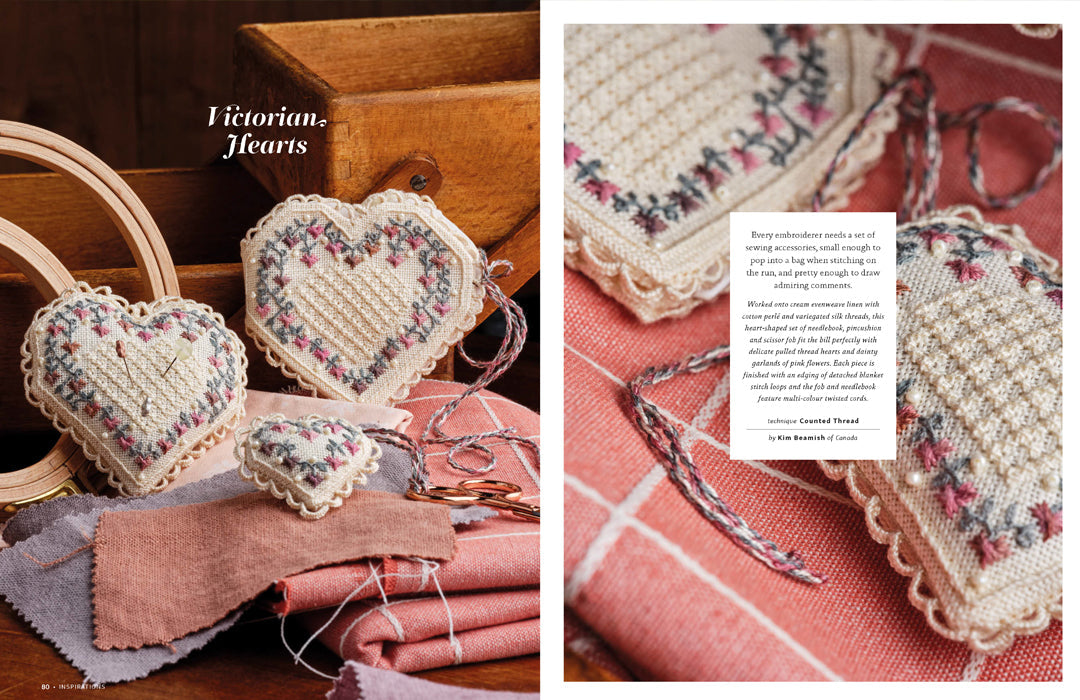 A book or magazine spread showing handmade heart-shaped embroidered or crocheted ornaments with lace trim, arranged on fabric and wooden props. The left panel includes the text 'Victorian Hearts,' and the right panel shows a close-up of one ornament with a small text box describing the project.
Photo by InspirationsStudios.com [additional_image_link]