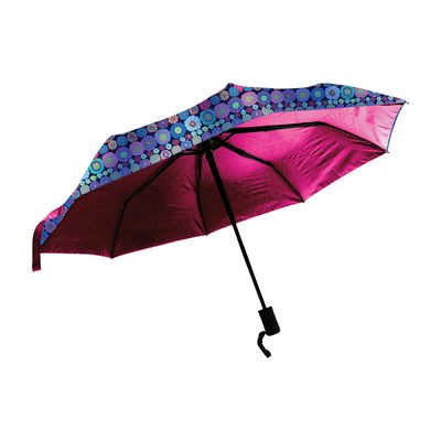 A compact folding umbrella shown open against a plain white background. The underside is bright pink, while the top edge features a blue and purple floral pattern.
Photo by Kaffe Fassett [image_link]