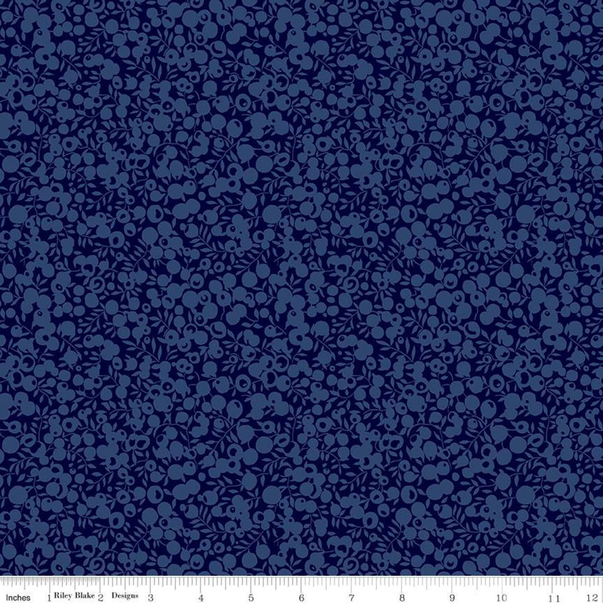 A close-up of a navy blue fabric with a repeating small floral or berry-like pattern in a slightly lighter blue. A white ruler strip is visible along the bottom edge with inch markings and the text 'Riley Blake Designs'.
[additional_image_link]