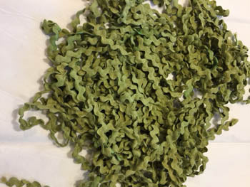 A green, solid-colored rick rack trim made of cotton, hand dyed, intended for use in cross stitch and embroidery finishing.
[image_link]