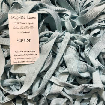 A bundle of blue cotton twill tape with a label indicating 'Lady Dot Creates HIP HOP TWILL 3/4in Trim 2 Yards Cotton Twill Hand Dyed Trim'.
[image_link]