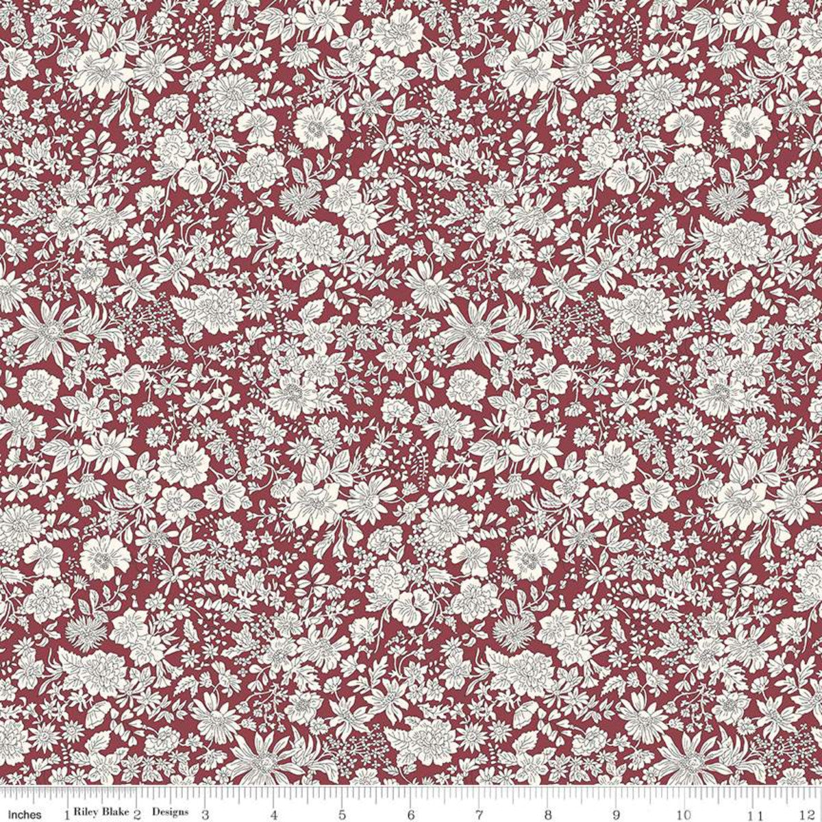 A close-up of a fabric pattern featuring a dense, repeating white floral and botanical print on a deep red background, with a ruler at the bottom indicating scale.
Photo by RileyBlakeDesigns.com [image_link]