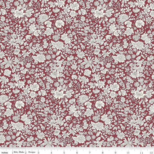 A close-up of a fabric pattern featuring a dense, repeating white floral and botanical print on a deep red background, with a ruler at the bottom indicating scale.
Photo by RileyBlakeDesigns.com [image_link]