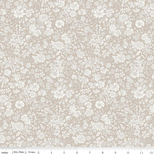 A close-up of a fabric pattern featuring a delicate white floral and leaf print on a warm beige background, with a ruler at the bottom indicating scale.
Photo by RileyBlakeDesigns.com [image_link]