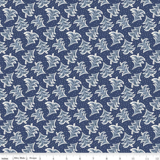 A repeating fabric pattern featuring stylized white and light blue leaf motifs on a dark navy blue background with small white dots, shown with a ruler along the bottom edge.
Photo by RileyBlakeDesigns.com [image_link]
