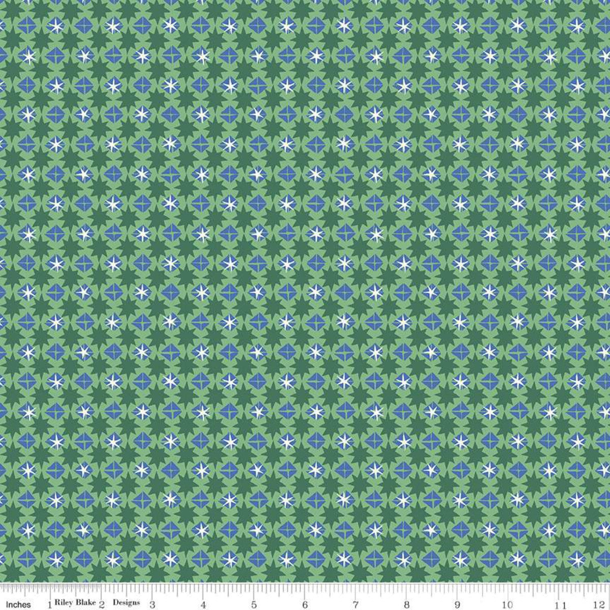 A repeating fabric pattern featuring green, light green, blue, and white geometric floral motifs, with a measuring ruler visible along the bottom edge.
Photo by RileyBlakeDesigns.com [image_link]