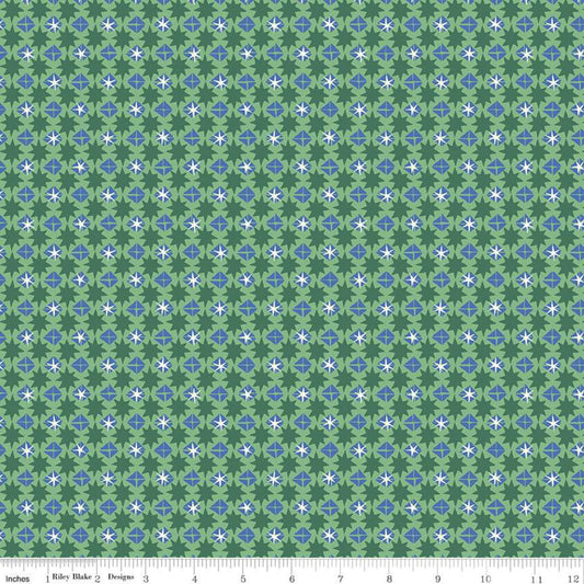 A repeating fabric pattern featuring green, light green, blue, and white geometric floral motifs, with a measuring ruler visible along the bottom edge.
Photo by RileyBlakeDesigns.com [image_link]