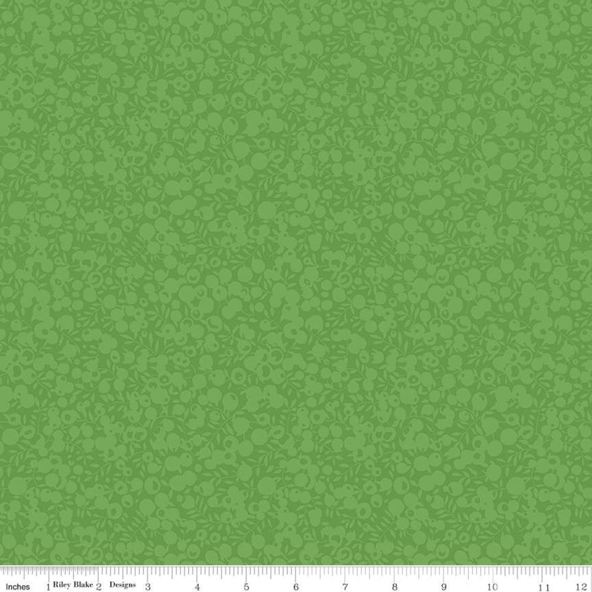 A close-up of a green patterned fabric or wallpaper sample with a repeating tonal floral motif and a small ruler strip along the bottom edge showing measurements.
Photo by RileyBlakeDesigns.com [image_link]