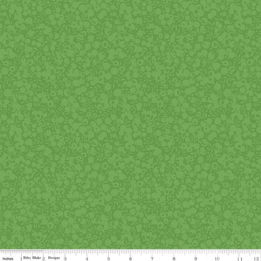 A close-up of a green patterned fabric or wallpaper sample with a repeating tonal floral motif and a small ruler strip along the bottom edge showing measurements.
Photo by RileyBlakeDesigns.com [image_link]